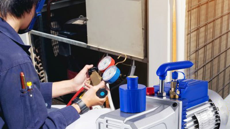 HVAC Technician Using Two-Stage Vacuum Pump