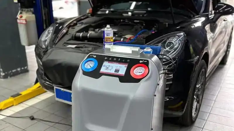Technician looking frustrated at slow refrigerant recovery machine