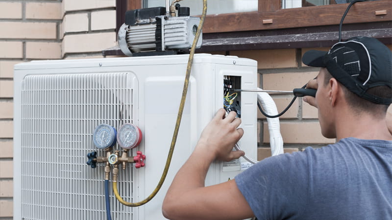 A professional HVAC technician with a vacuum pump_