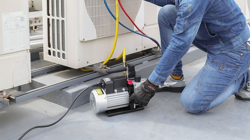 AC vacuum pump sitting on a flat commercial rooftop next to an HVAC unit