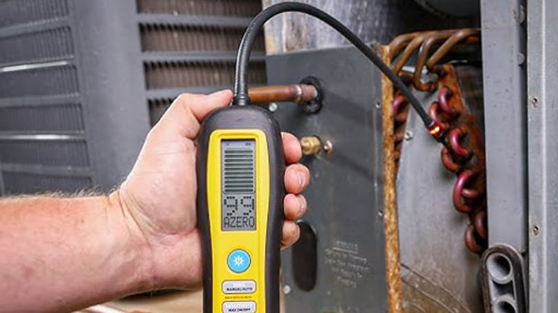 Technician using multiple leak detection tools on an HVAC unit