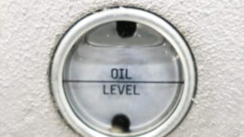 Vacuum pump with oil visibly over the max fill line on the sight glass, possibly with some oil misting
