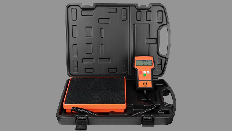 HVAC technician using a digital refrigerant scale next to an AC unit
