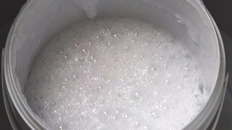 A shot looking down into a clear vacuum chamber, where a container of resin is actively 