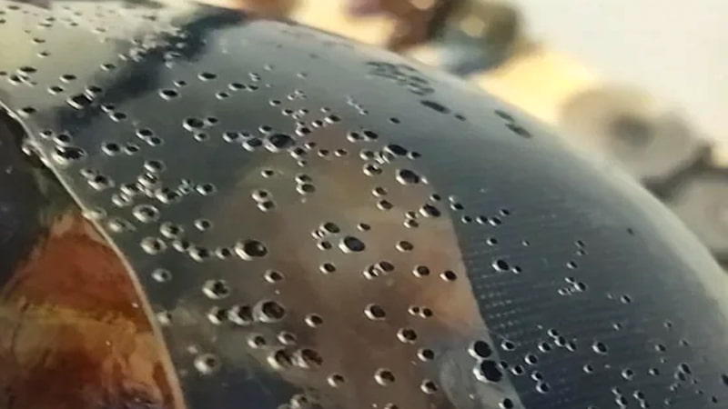 A perfectly clear, bubble-free resin casting of a crystal sitting next to a flawed, cloudy casting filled with tiny bubbles