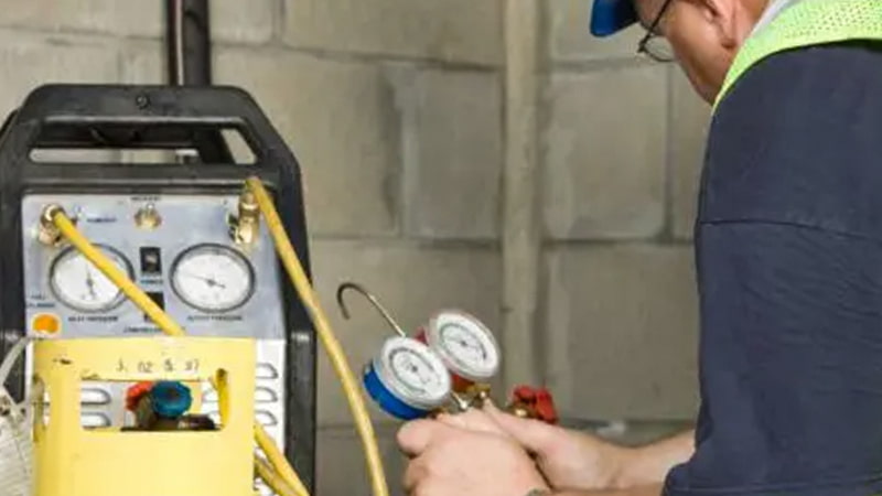 Technician Checking Recovery Cylinder Gauge