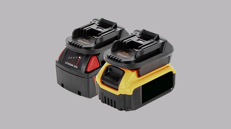 A technician's hands decisively sliding a red Milwaukee power tool battery onto a special adapter fitted on a cordless vacuum pump